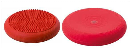 Zwei rote Balance-Pads, eines mit Noppen, das andere glatt, nebeneinander auf weißem Hintergrund.