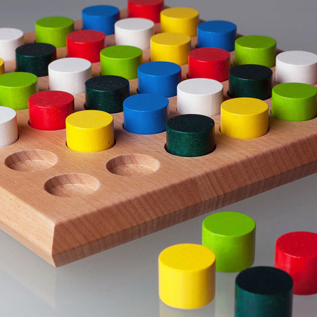 Holzspiel mit bunten, runden Spielsteinen in verschiedenen Farben auf einem Holzbrett.