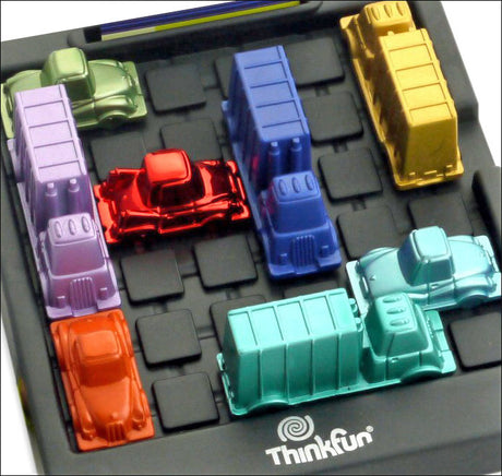 Bunte Spielzeug-LKWs auf einem schwarzen Spielbrett mit grauen Feldern, Marke Thinkfun.