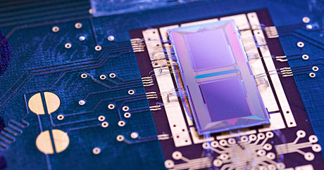 Nahaufnahme eines Computerchips auf einer Leiterplatte mit sichtbaren Schaltkreisen.