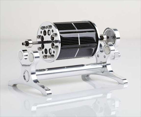 Drehmaschine mit schwarzem, zylindrischem Rotor und metallischen Endstücken auf einer weißen Oberfläche.