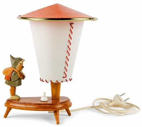 Ein Tischlampe mit einem Lampenschirm in Form eines Eis, auf einem Holzsockel, mit einem kleinen Holzfigur neben.