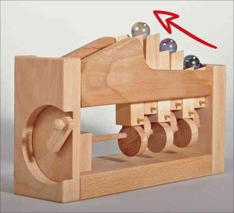 Holz-Murmelbahn mit vier Kugeln, eine Kugel ist im oberen Bereich, rote Pfeil zeigt nach oben.