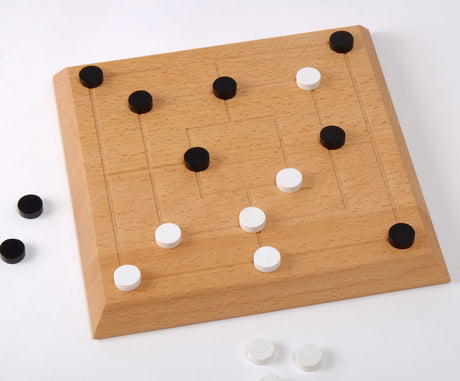 Holzbrett mit schwarzen und weißen Spielsteinen, einige Steine liegen daneben.