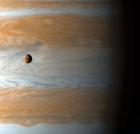 Der Planet Jupiter mit seinem Großen Roten Fleck und einem Mond im Vordergrund.