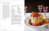 Buchseite mit Text auf der linken Seite und auf der rechten Seite ein Kuchen mit Biskuitrollen, Beeren, Fruchtgummi und Dekoration