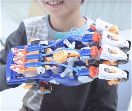 Kind hält einen blauen, weißen und orange Roboterarm aus Spielzeug in die Kamera.