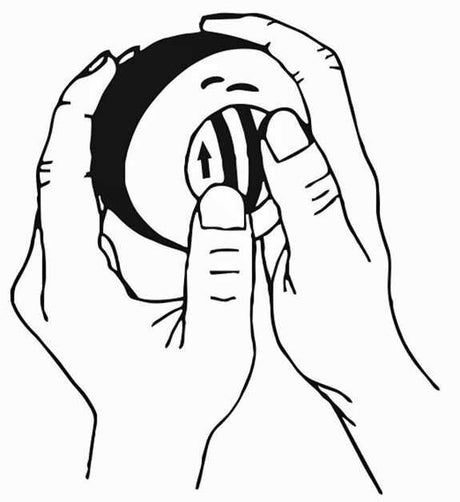 Zwei Hände halten eine runde Objekt mit einem Pfeil und Streifen, vermutlich eine Kameraobjektiv.