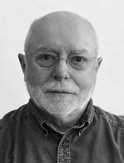 Schwarz-weißes Portrait eines älteren Mannes mit Brille, weißem Bart und Glatze, trägt eine Jeansjacke.