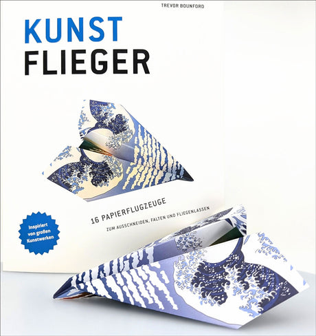 Buchcover mit Titel "Kunst Flieger", zeigt ein gefaltetes Papierflugzeug mit "The Great Wave" Muster.