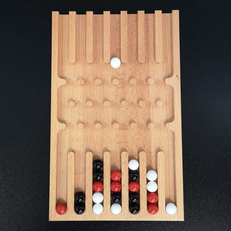 Holz-Backgammon-Spiel mit schwarzen, weißen und roten Spielsteinen auf schwarzem Hintergrund.
