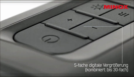 Nahaufnahme eines Tastaturteils mit Text "5-fache digitale Vergrößerung (kombiniert: bis 30-fach)" und "MINOX" in roter Schrift.