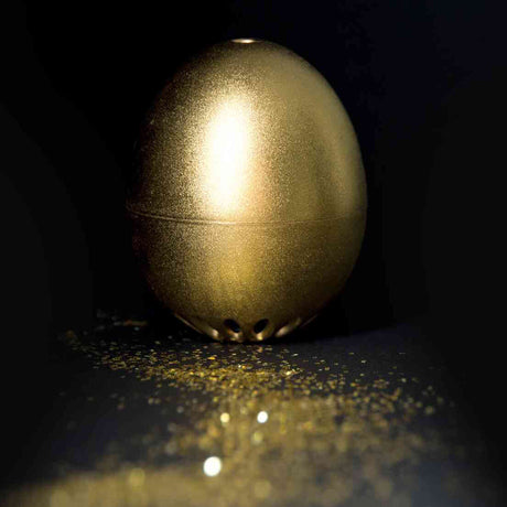Goldenes Piepei, auf schwarzem Hintergrund, mit Goldstaub auf Oberfläche.