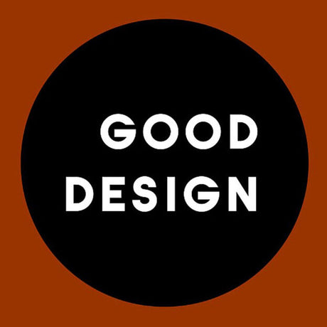 Schwarzer Kreis mit weißen Text "GOOD DESIGN" auf braunem Hintergrund.